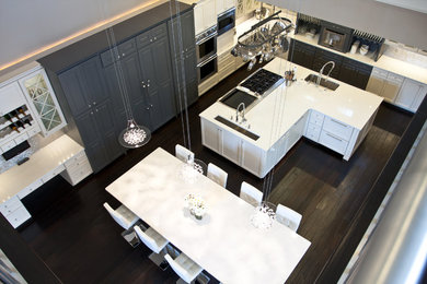 Large minimalist l-shaped dark wood floor and brown floor eat-in kitchen photo in Miami with an undermount sink, shaker cabinets, white cabinets, metallic backsplash, mosaic tile backsplash, stainless steel appliances and an island