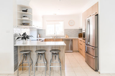 キャンベラにある高級な中くらいなコンテンポラリースタイルのおしゃれなキッチン (フラットパネル扉のキャビネット、青いキッチンパネル、シルバーの調理設備、白いキッチンカウンター) の写真
