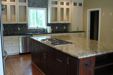 Exempel på ett avskilt, stort klassiskt l-kök, med en undermonterad diskho, skåp i shakerstil, vita skåp, granitbänkskiva, grått stänkskydd, stänkskydd i stenkakel, rostfria vitvaror, mellanmörkt trägolv och en köksö