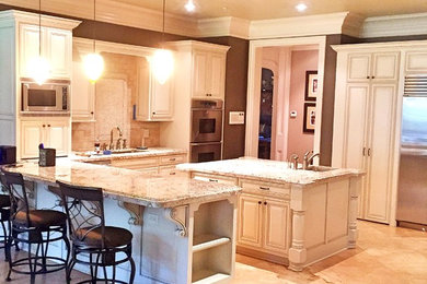 Example of a huge classic marble floor eat-in kitchen design in Atlanta with a double-bowl sink, raised-panel cabinets, white cabinets, granite countertops, brown backsplash, stone tile backsplash, stainless steel appliances and an island