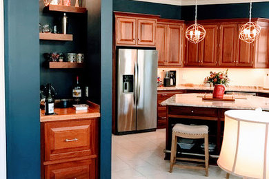 ジャクソンビルにあるトランジショナルスタイルのおしゃれなキッチン (インセット扉のキャビネット、中間色木目調キャビネット、御影石カウンター、白いキッチンパネル、セラミックタイルのキッチンパネル、シルバーの調理設備) の写真
