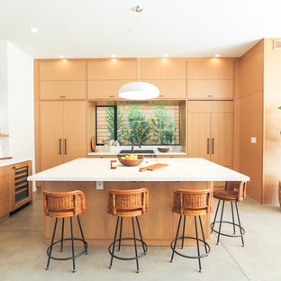 Contemporary kitchen inspiration - Kitchen - contemporary concrete floor and gray floor kitchen idea in Los Angeles with an undermount sink, flat-panel cabinets, light wood cabinets, window backsplash, paneled appliances and an island
