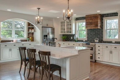 Inspiration for a large farmhouse single-wall light wood floor and brown floor eat-in kitchen remodel in Nashville with a farmhouse sink, beaded inset cabinets, white cabinets, marble countertops, gray backsplash, cement tile backsplash, stainless steel appliances, an island and white countertops