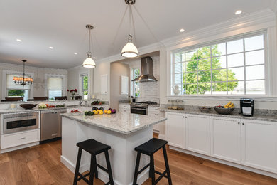 Large light wood floor eat-in kitchen photo in Boston with white cabinets, granite countertops, white backsplash, stainless steel appliances and two islands