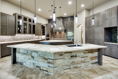 Huge transitional l-shaped travertine floor open concept kitchen photo in Houston with an undermount sink, shaker cabinets, medium tone wood cabinets, granite countertops, multicolored backsplash, matchstick tile backsplash, paneled appliances and two islands