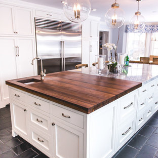Photo of a large country u-shaped eat-in kitchen in New York with an undermount sink, recessed-panel cabinets, white cabinets, quartz benchtops, stainless steel appliances, slate floors, with island, black floor, grey splashback and marble splashback.