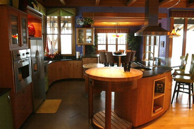 Esempio di un grande cucina con isola centrale minimal con ante con bugna sagomata, ante in legno chiaro, top in granito, elettrodomestici in acciaio inossidabile e parquet chiaro