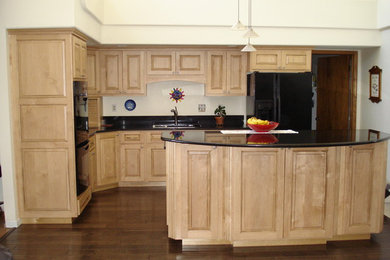 Inspiration for a large timeless l-shaped eat-in kitchen remodel in Denver with raised-panel cabinets, light wood cabinets, black appliances and an island