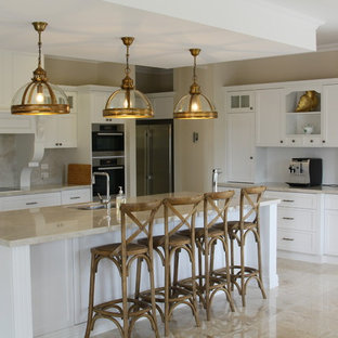 Inspiration for a traditional l-shaped eat-in kitchen in Other with an undermount sink, shaker cabinets, white cabinets, beige splashback, panelled appliances, with island, beige floor and beige benchtop.