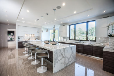 Trendy u-shaped kitchen photo in Los Angeles with an undermount sink, flat-panel cabinets, dark wood cabinets, white backsplash and an island