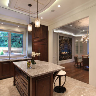 Large eclectic l-shaped kitchen in Vancouver with a double-bowl sink, dark wood cabinets, panelled appliances, raised-panel cabinets, marble benchtops, stone slab splashback, porcelain floors and with island.