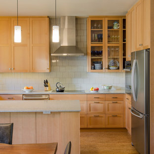 Diseño de cocina contemporánea con armarios con paneles empotrados, puertas de armario de madera clara, salpicadero blanco, salpicadero de azulejos de cerámica, electrodomésticos de acero inoxidable, una isla y suelo de corcho