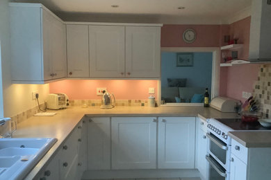 Design ideas for a medium sized classic u-shaped enclosed kitchen in Other with shaker cabinets, white cabinets, laminate countertops and mosaic tiled splashback.