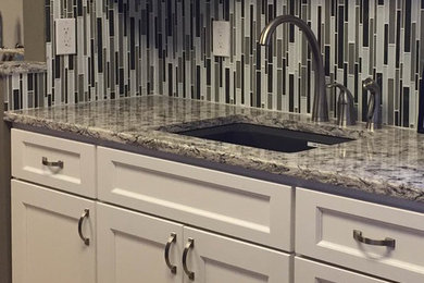 Example of a mid-sized transitional ceramic tile kitchen design in Orange County with an undermount sink, shaker cabinets, white cabinets, granite countertops, multicolored backsplash, matchstick tile backsplash, stainless steel appliances and an island