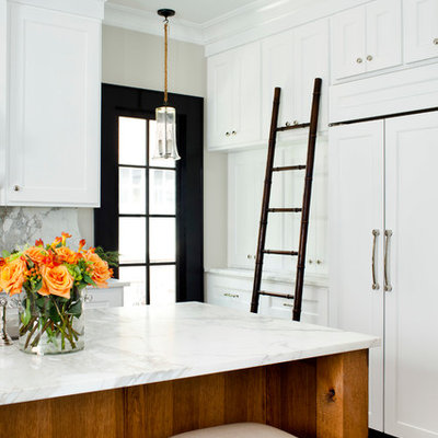 Inspiration for a mid-sized timeless l-shaped medium tone wood floor enclosed kitchen remodel in Atlanta with marble countertops, an undermount sink, recessed-panel cabinets, white cabinets, white backsplash, paneled appliances and an island