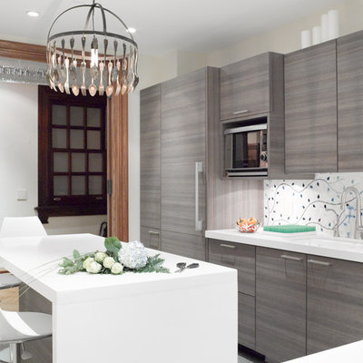 Eat-in kitchen - mid-sized transitional l-shaped eat-in kitchen idea in New York with an undermount sink, flat-panel cabinets, gray cabinets, paneled appliances, quartz countertops, multicolored backsplash and an island