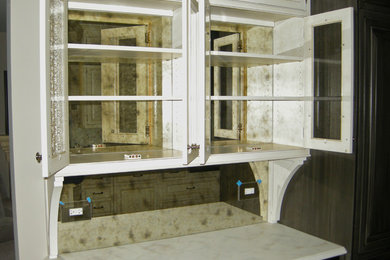 Ejemplo de cocina clásica de tamaño medio con armarios tipo vitrina, puertas de armario blancas, encimera de mármol, salpicadero metalizado y salpicadero con efecto espejo