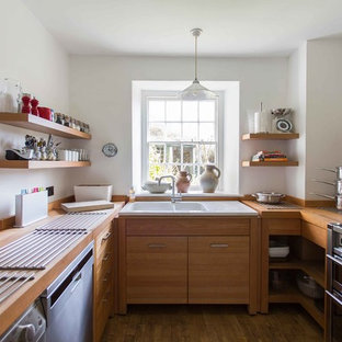Small contemporary u-shaped enclosed kitchen in London with medium wood cabinets, stainless steel appliances, medium hardwood flooring, brown floors, a built-in sink, flat-panel cabinets, wood worktops, white splashback and no island.