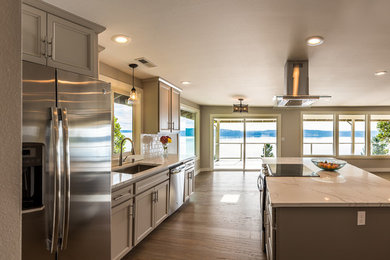 Inspiration for a mid-sized transitional medium tone wood floor and brown floor kitchen remodel in Seattle with an undermount sink, quartzite countertops, white backsplash, subway tile backsplash, stainless steel appliances, recessed-panel cabinets, white cabinets and an island