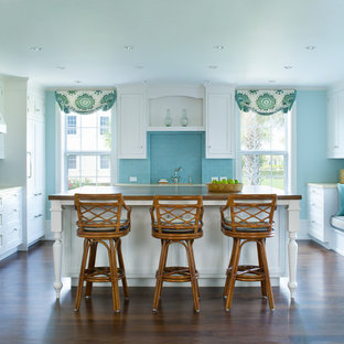 Foto di una cucina stile marinaro di medie dimensioni con ante in stile shaker, ante bianche, paraspruzzi blu, paraspruzzi con piastrelle diamantate, parquet scuro, isola, lavello sottopiano, top in legno e elettrodomestici in acciaio inossidabile