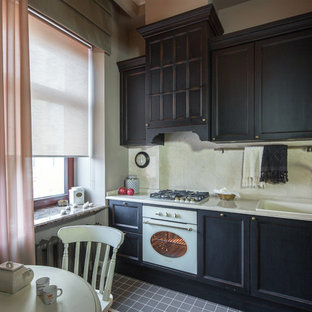 Design ideas for a traditional l-shaped eat-in kitchen in Moscow with black cabinets, white splashback, white appliances, no island, grey floor, a drop-in sink and recessed-panel cabinets.