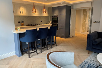 This is an example of a modern kitchen in London with light hardwood flooring.