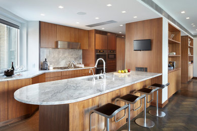Inspiration for a large contemporary galley porcelain tile and gray floor open concept kitchen remodel in New York with an undermount sink, flat-panel cabinets, medium tone wood cabinets, gray backsplash, stone slab backsplash, stainless steel appliances, granite countertops and a peninsula