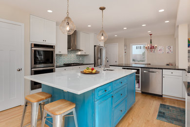 Large trendy u-shaped light wood floor and beige floor eat-in kitchen photo in DC Metro with a farmhouse sink, shaker cabinets, white cabinets, granite countertops, blue backsplash, cement tile backsplash, stainless steel appliances, an island and black countertops