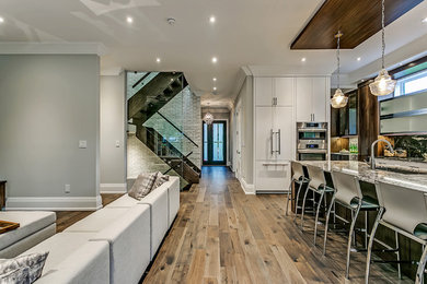 Enclosed kitchen - huge contemporary u-shaped dark wood floor and brown floor enclosed kitchen idea in Toronto with an undermount sink, flat-panel cabinets, white cabinets, granite countertops, stainless steel appliances and an island