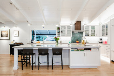 Inspiration for a large transitional l-shaped light wood floor eat-in kitchen remodel in Denver with an undermount sink, white cabinets, green backsplash, mosaic tile backsplash, paneled appliances, an island, gray countertops, shaker cabinets and granite countertops