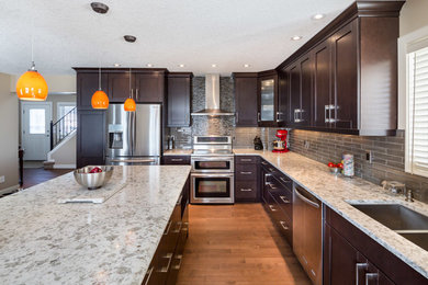 Eat-in kitchen - mid-sized contemporary light wood floor eat-in kitchen idea in Calgary with an undermount sink, recessed-panel cabinets, dark wood cabinets, quartzite countertops, gray backsplash, subway tile backsplash, stainless steel appliances and an island