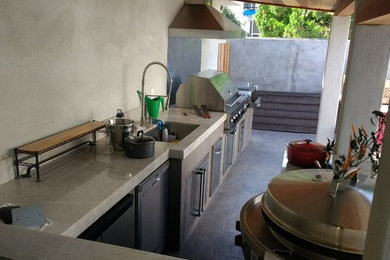 Inspiration for a mid-sized contemporary backyard patio kitchen remodel in Los Angeles with a roof extension