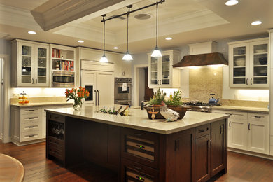 Example of a classic kitchen design in Phoenix with paneled appliances, glass-front cabinets, white cabinets, granite countertops, beige backsplash and stone slab backsplash