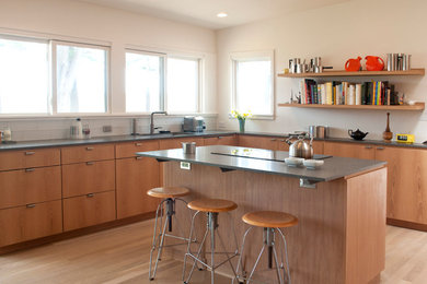 Diseño de cocina minimalista con fregadero bajoencimera, armarios con paneles lisos, puertas de armario de madera oscura, salpicadero blanco, salpicadero de azulejos de vidrio, electrodomésticos de acero inoxidable, suelo de madera clara, una isla y encimera de esteatita