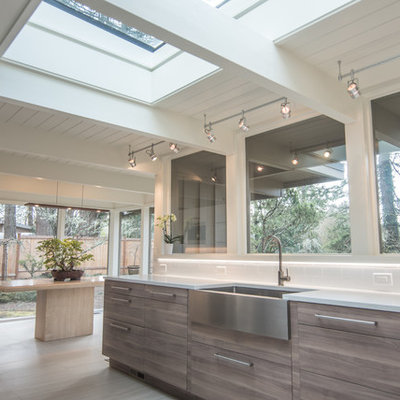 Example of a large 1950s galley porcelain tile and white floor eat-in kitchen design in Portland with a farmhouse sink, flat-panel cabinets, brown cabinets, quartz countertops, white backsplash, porcelain backsplash, stainless steel appliances, no island and white countertops