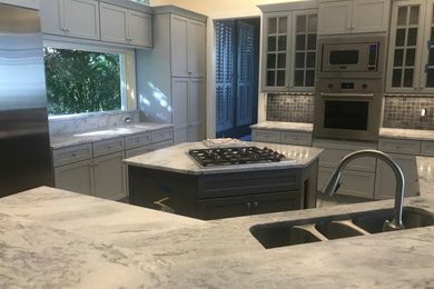 Inspiration for a large transitional porcelain tile and gray floor eat-in kitchen remodel in Miami with a triple-bowl sink, flat-panel cabinets, gray cabinets, marble countertops, gray backsplash, slate backsplash, stainless steel appliances, two islands and gray countertops