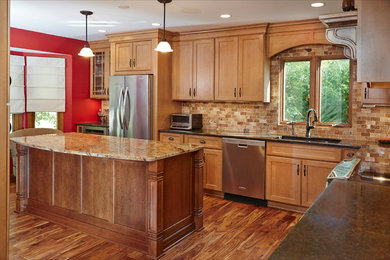 Inspiration for a large timeless l-shaped medium tone wood floor kitchen remodel in Minneapolis with a double-bowl sink, flat-panel cabinets, light wood cabinets, granite countertops, multicolored backsplash, stone tile backsplash, stainless steel appliances and an island