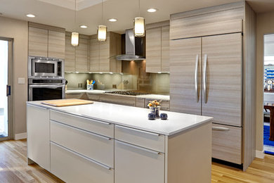 Photo of a contemporary l-shaped kitchen in Sacramento with flat-panel cabinets, grey cabinets, integrated appliances, medium hardwood flooring and an island.