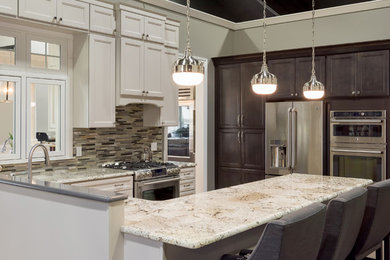 Example of a large classic u-shaped open concept kitchen design in Grand Rapids with recessed-panel cabinets, white cabinets, granite countertops, multicolored backsplash, glass tile backsplash, stainless steel appliances, a peninsula and an undermount sink