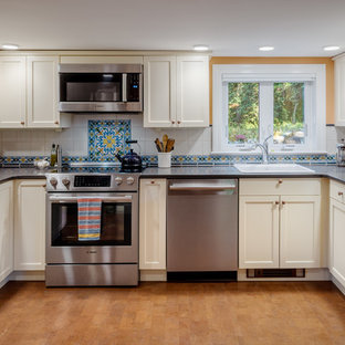Traditional kitchen appliance - Elegant u-shaped cork floor and brown floor kitchen photo in Boston with a drop-in sink, shaker cabinets, soapstone countertops, multicolored backsplash, ceramic backsplash, stainless steel appliances, no island, black countertops and beige cabinets