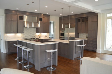 Huge transitional l-shaped dark wood floor open concept kitchen photo in DC Metro with an undermount sink, shaker cabinets, gray cabinets, marble countertops, gray backsplash, ceramic backsplash, stainless steel appliances and two islands