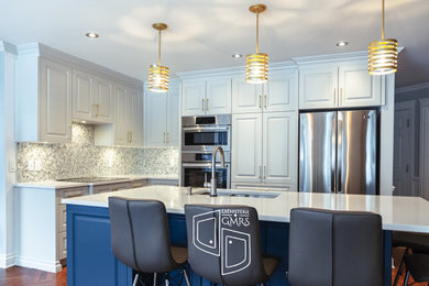 モントリオールにある高級な広いトランジショナルスタイルのおしゃれなキッチン (アンダーカウンターシンク、レイズドパネル扉のキャビネット、青いキャビネット、クオーツストーンカウンター、ベージュキッチンパネル、セラミックタイルのキッチンパネル、シルバーの調理設備、濃色無垢フローリング、茶色い床、白いキッチンカウンター) の写真