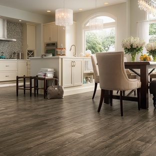 This is an example of a mid-sized shabby-chic style l-shaped eat-in kitchen in Other with beige cabinets, grey splashback, laminate floors, a peninsula, shaker cabinets, mosaic tile splashback and stainless steel appliances.