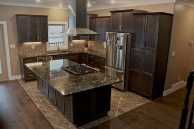 Open concept kitchen - craftsman l-shaped ceramic tile open concept kitchen idea in Vancouver with an undermount sink, shaker cabinets, dark wood cabinets, quartz countertops, gray backsplash, mosaic tile backsplash, stainless steel appliances and an island