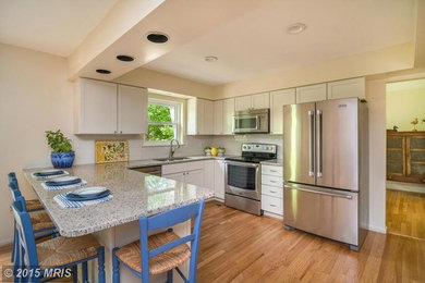 Example of a mid-sized trendy u-shaped medium tone wood floor eat-in kitchen design in Baltimore with a double-bowl sink, shaker cabinets, white cabinets, granite countertops, white backsplash, ceramic backsplash, stainless steel appliances and an island