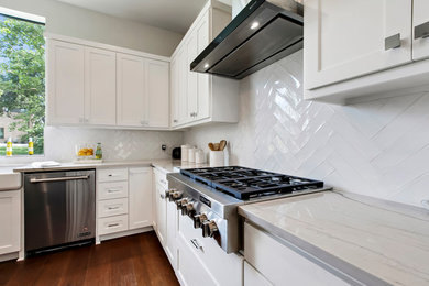 Inspiration for a large transitional l-shaped medium tone wood floor and brown floor open concept kitchen remodel in Austin with a farmhouse sink, shaker cabinets, white cabinets, quartzite countertops, white backsplash, terra-cotta backsplash, stainless steel appliances, an island and white countertops
