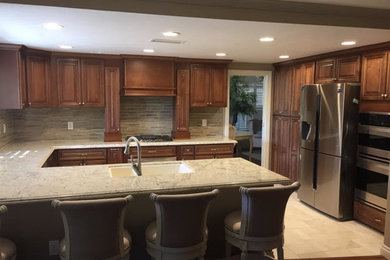 Foto på ett stort funkis kök, med en undermonterad diskho, luckor med upphöjd panel, skåp i mörkt trä, granitbänkskiva, flerfärgad stänkskydd, stänkskydd i glaskakel, rostfria vitvaror, en halv köksö och klinkergolv i keramik