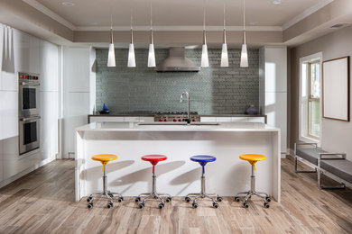 Inspiration for a mid-sized contemporary l-shaped porcelain tile and brown floor kitchen remodel in Atlanta with an undermount sink, flat-panel cabinets, white cabinets, metallic backsplash, metal backsplash, stainless steel appliances, an island, white countertops and quartzite countertops