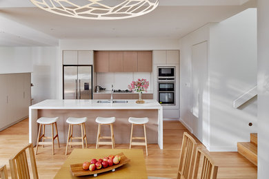 Einzeilige, Mittelgroße Moderne Wohnküche mit Doppelwaschbecken, Rückwand aus Keramikfliesen, Küchengeräten aus Edelstahl, braunem Holzboden, Kücheninsel und hellen Holzschränken in Sydney