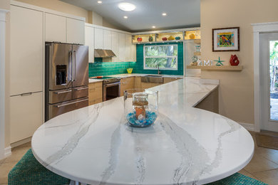 Inspiration for a mid-sized coastal galley eat-in kitchen remodel in Tampa with a farmhouse sink, flat-panel cabinets, white cabinets, granite countertops, blue backsplash, mosaic tile backsplash, stainless steel appliances and no island